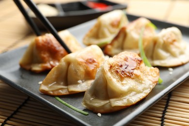 Photo of Delicious fried gyoza dumplings on table, closeup