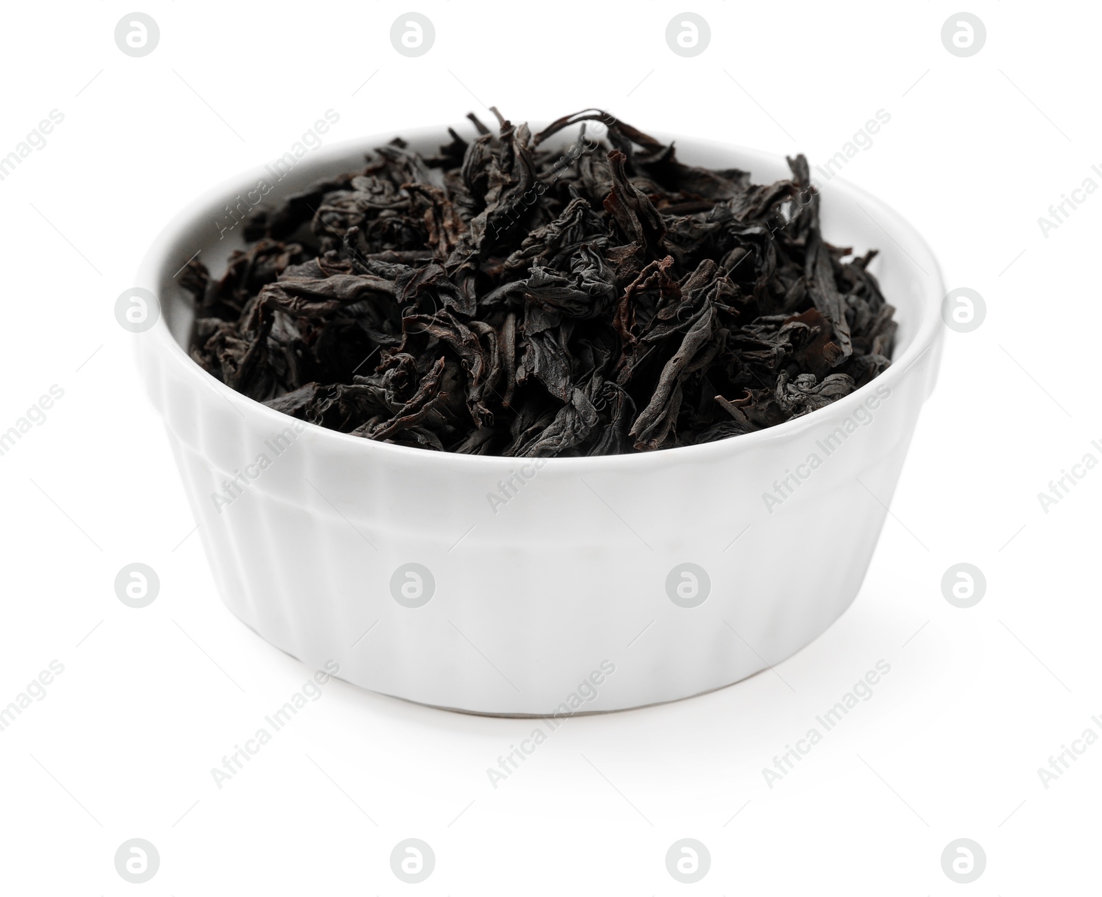 Photo of Dry tea leaves in bowl isolated on white