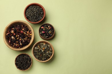 Photo of Different types of tea brew on olive background, flat lay. Space for text