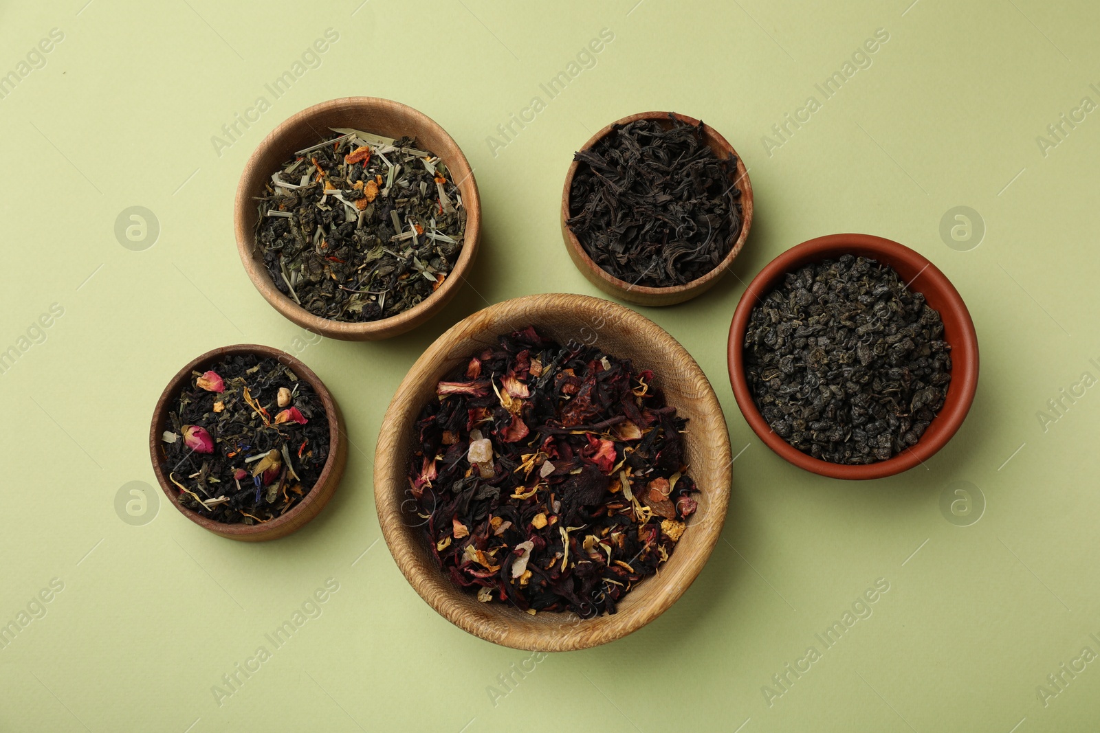 Photo of Different types of tea brew on olive background, flat lay