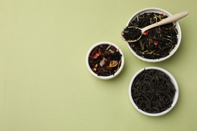 Photo of Different types of tea brew on olive background, flat lay. Space for text