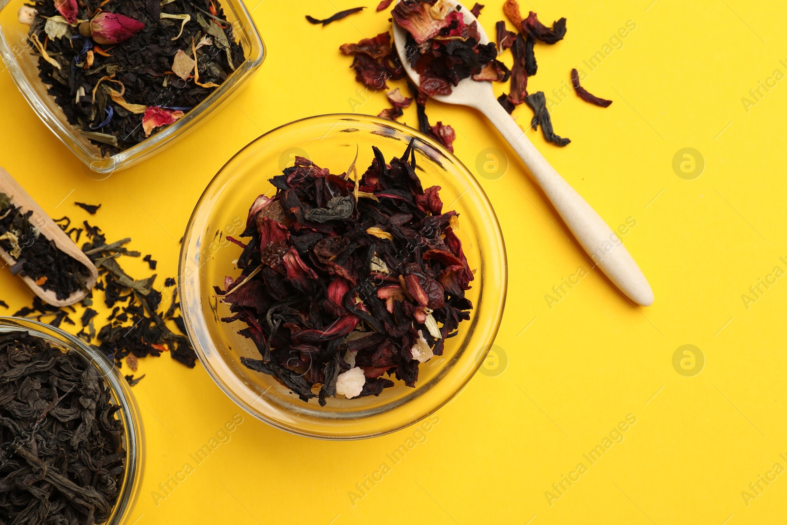 Photo of Different types of tea brew on yellow background, flat lay