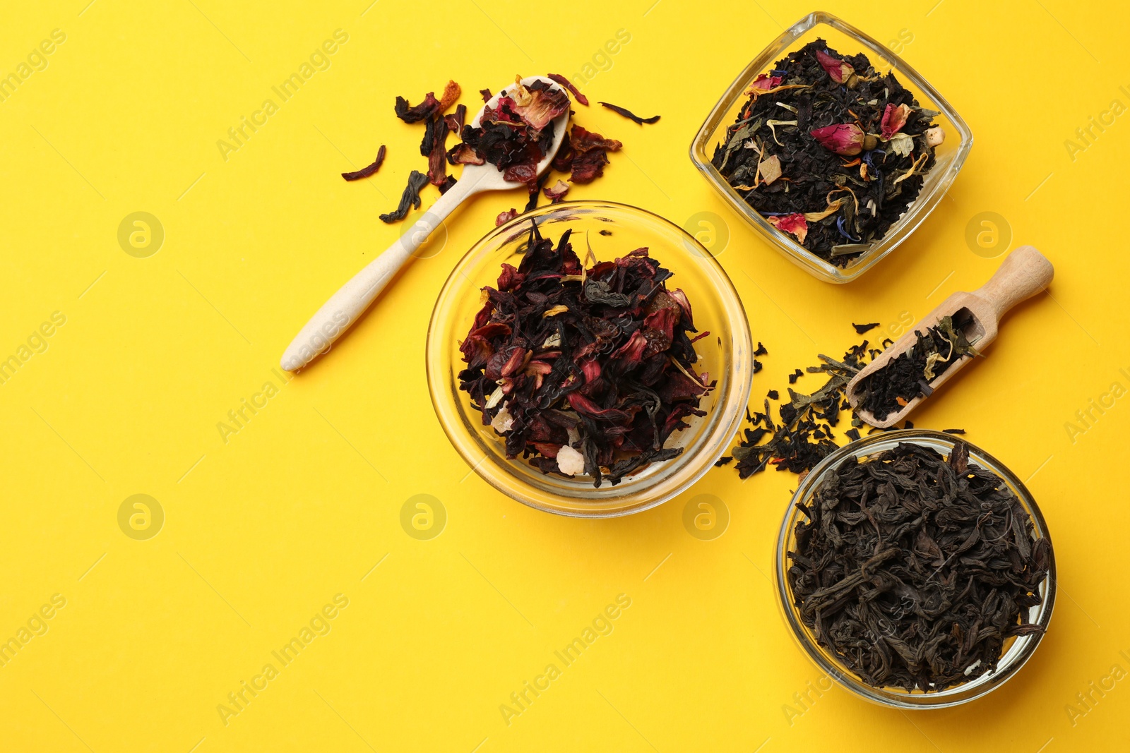 Photo of Different types of tea brew on yellow background, flat lay. Space for text