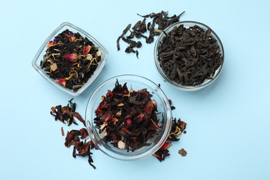 Photo of Different types of tea brew on light blue background, flat lay