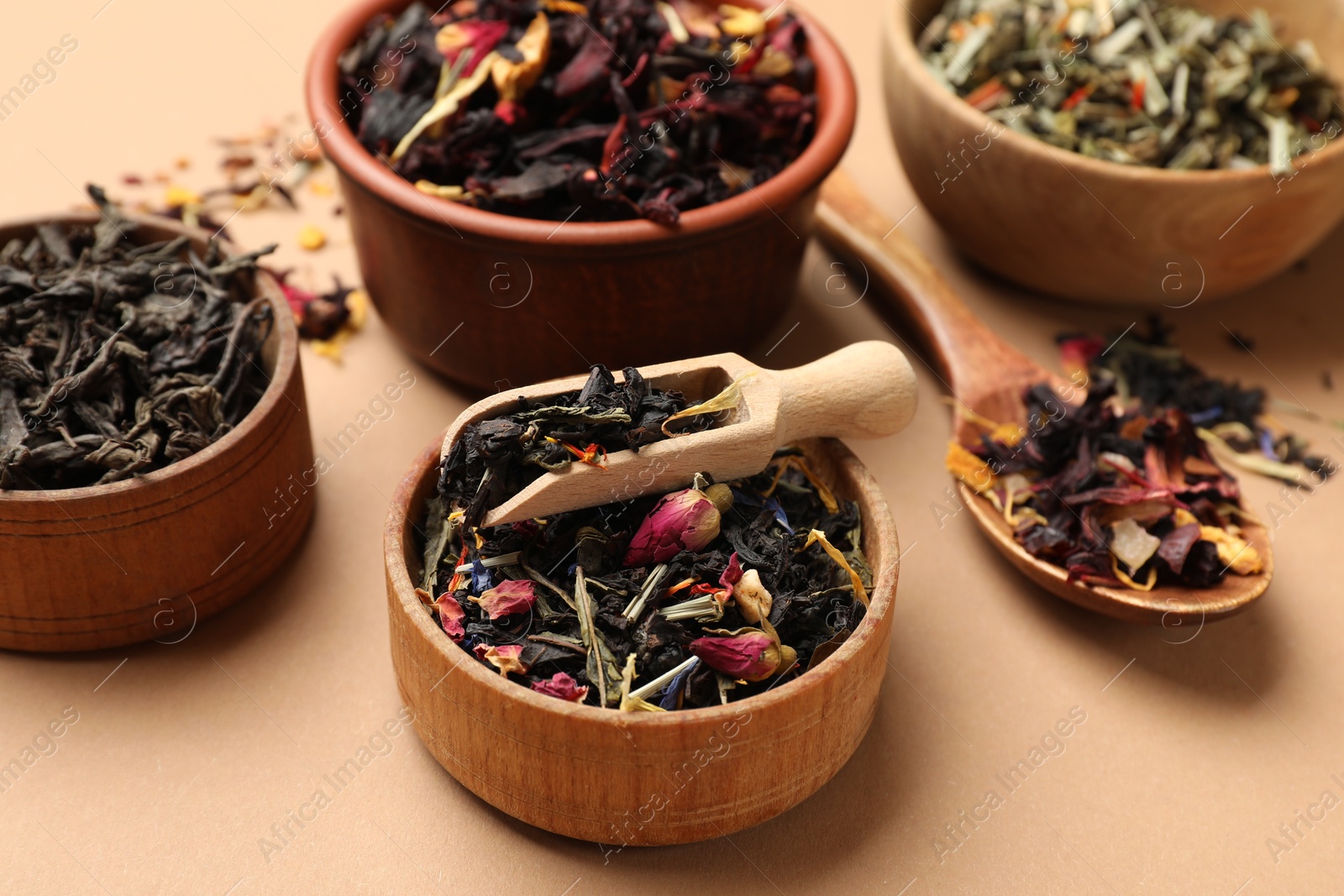 Photo of Different types of tea brew on brown background, closeup