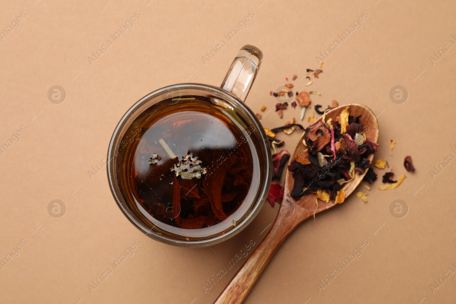 Photo of Aromatic tea and dried leaves on brown background, flat lay