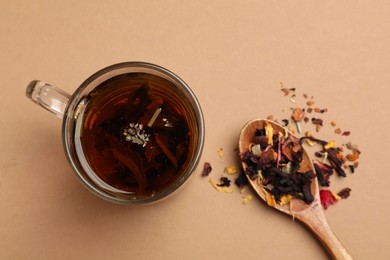 Photo of Aromatic tea and dried leaves on brown background, flat lay