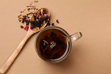 Photo of Aromatic tea and dried leaves on brown background, flat lay