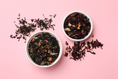 Photo of Different types of tea brew on light pink background, flat lay