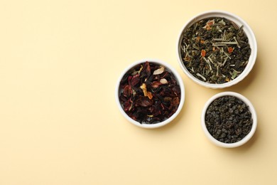 Photo of Different types of tea brew on beige background, flat lay. Space for text