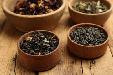 Photo of Different types of tea brew on wooden table, closeup