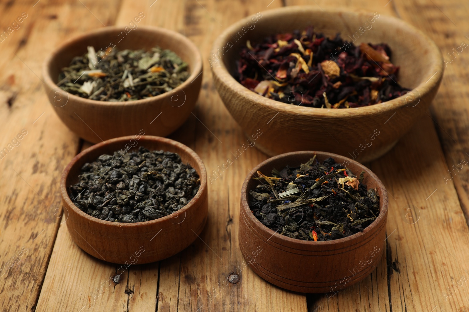 Photo of Different types of tea brew on wooden table, closeup