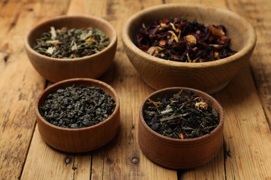 Photo of Different types of tea brew on wooden table, closeup