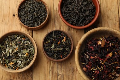 Photo of Different types of tea brew on wooden table, flat lay