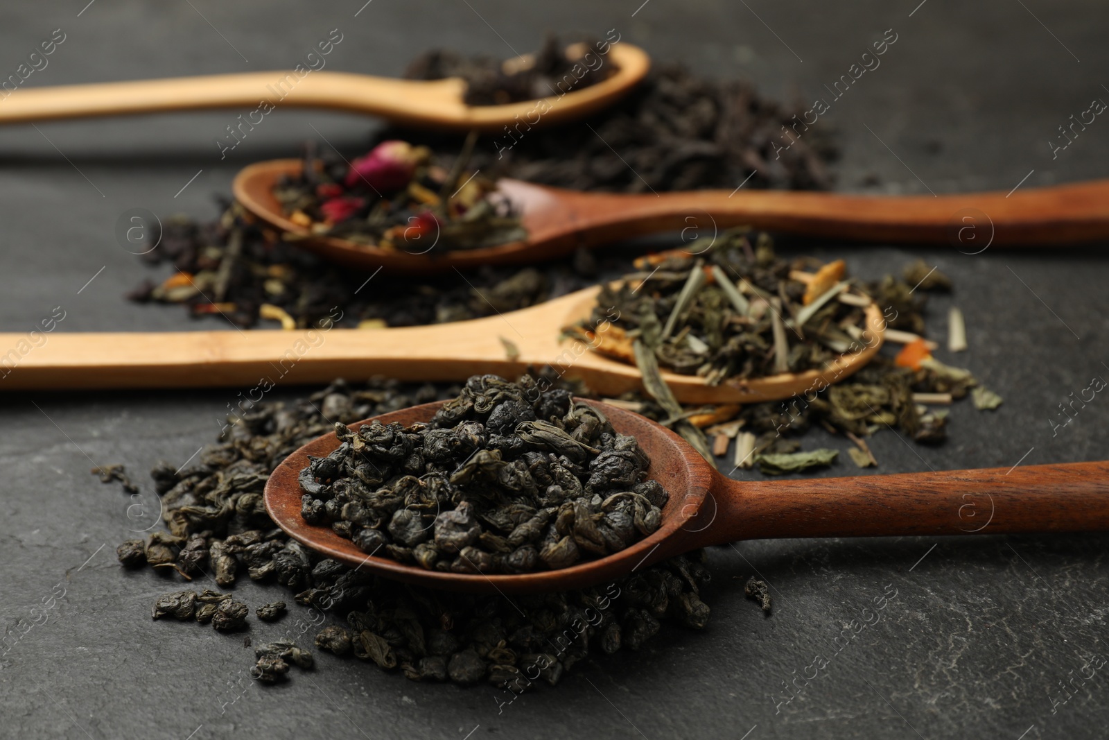 Photo of Different types of tea brew on black table, closeup