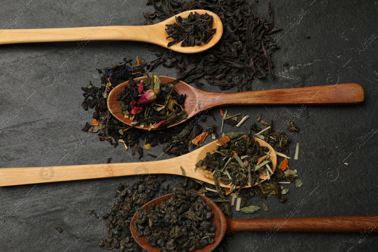 Photo of Different types of tea brew on black table, flat lay