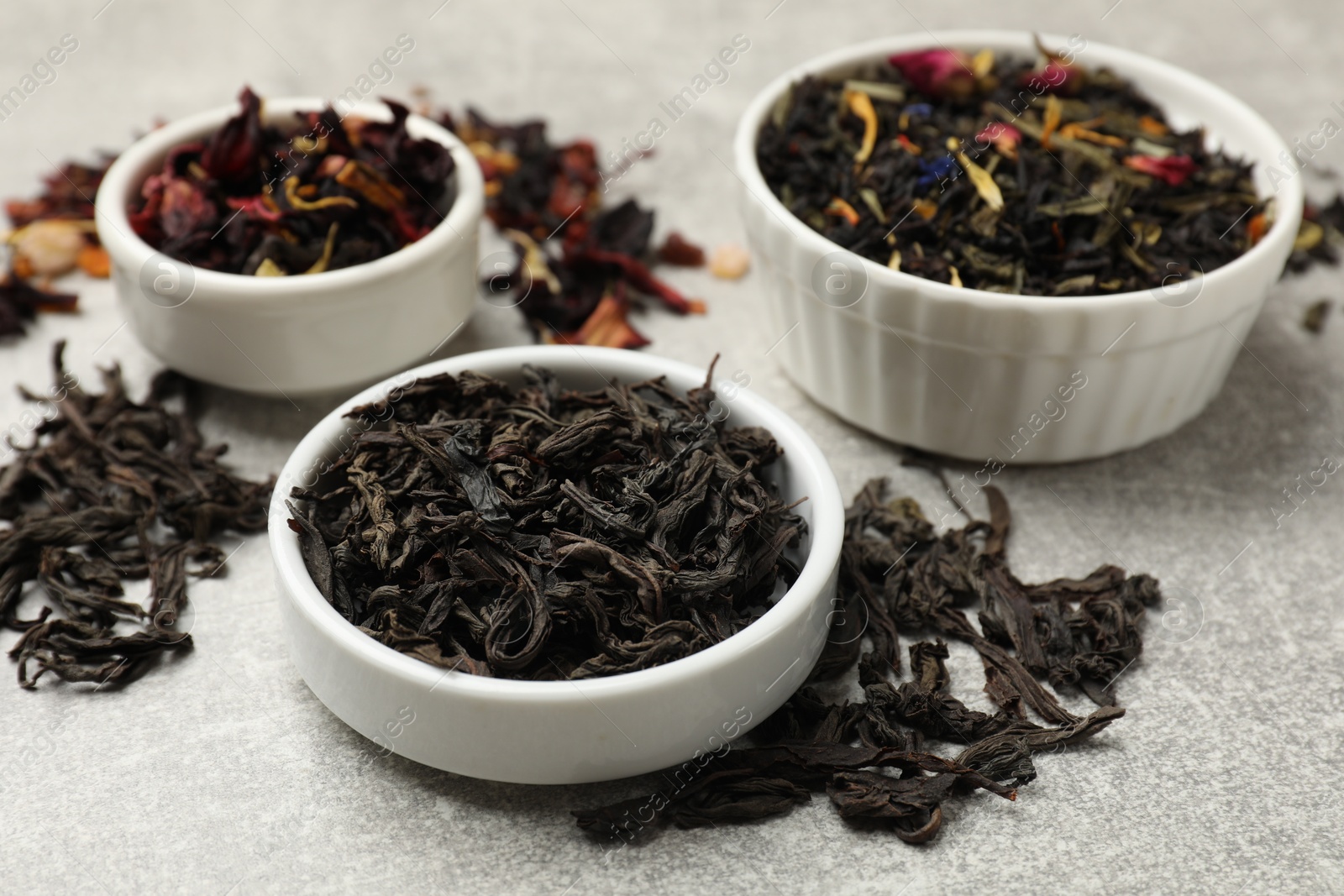 Photo of Different types of tea brew on grey table, closeup