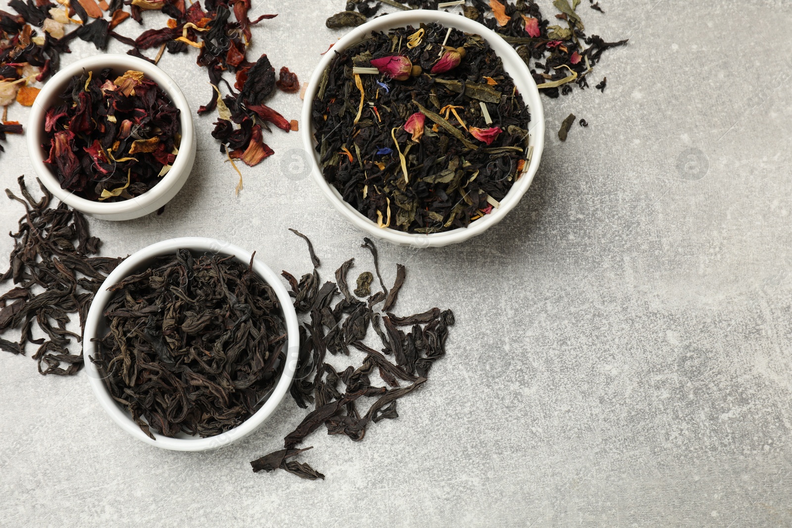 Photo of Different types of tea brew on grey table, flat lay