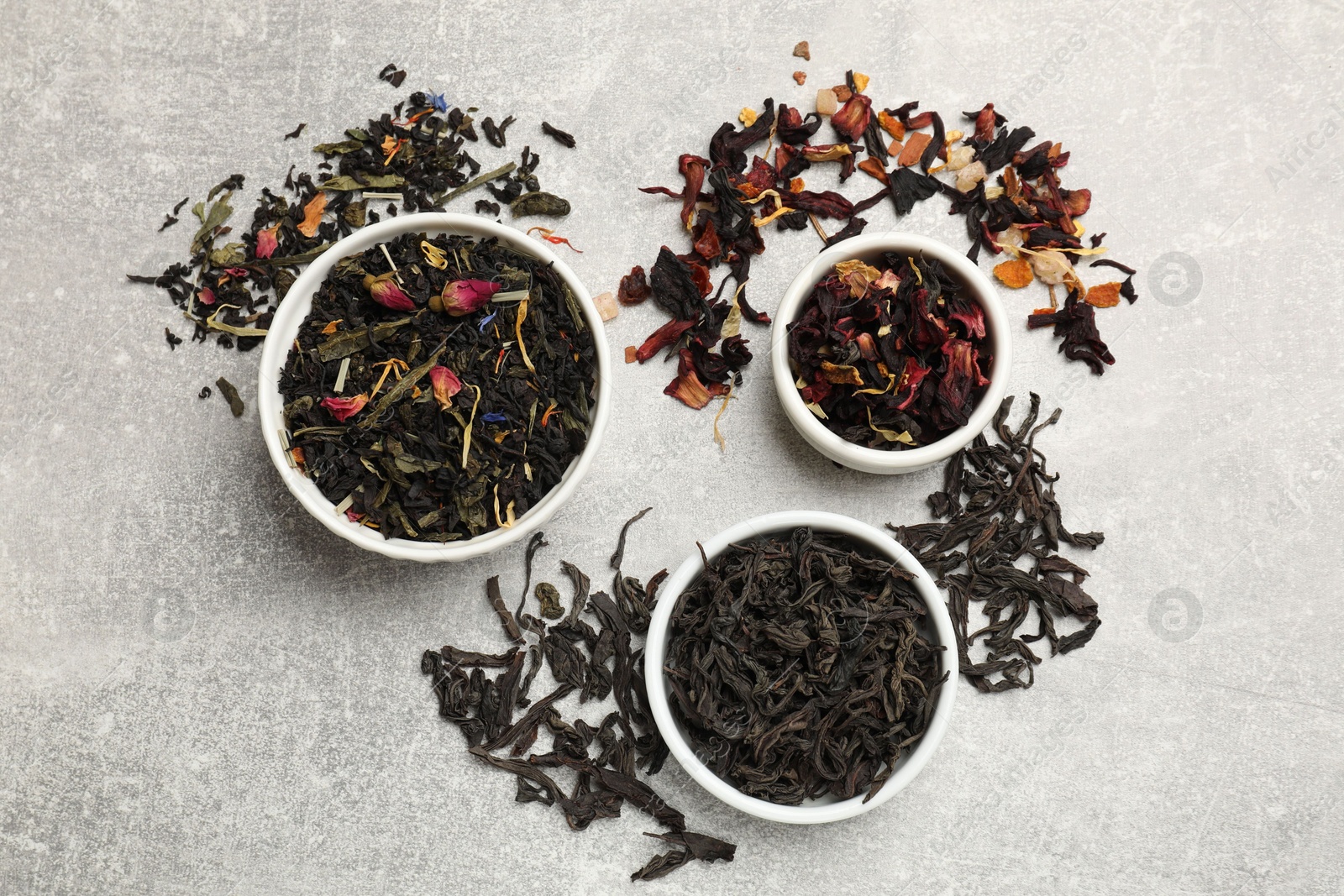 Photo of Different types of tea brew on grey table, flat lay