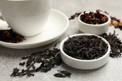 Photo of Aromatic tea and dried leaves on grey table, closeup