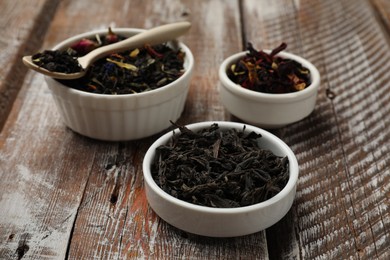 Photo of Different types of tea brew on wooden table, closeup