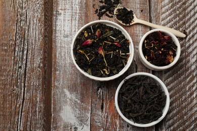 Photo of Different types of tea brew on wooden table, flat lay. Space for text