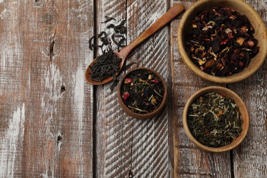 Photo of Different types of tea brew on wooden table, flat lay. Space for text