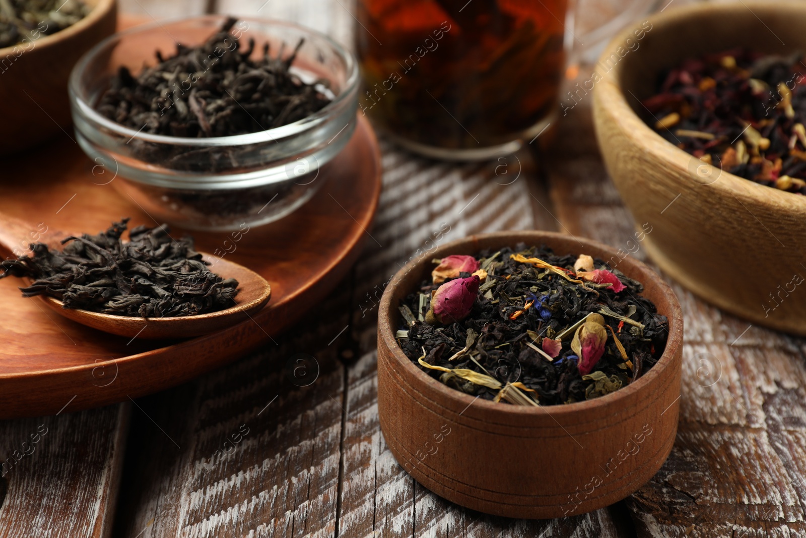 Photo of Different types of tea brew on wooden table, closeup