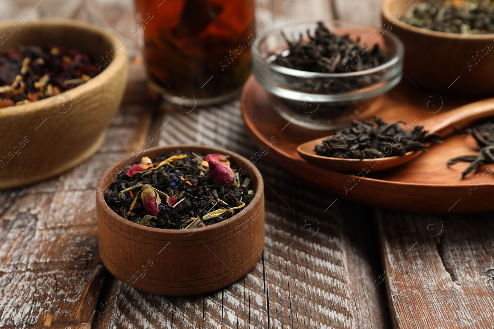 Photo of Different types of tea brew on wooden table, closeup