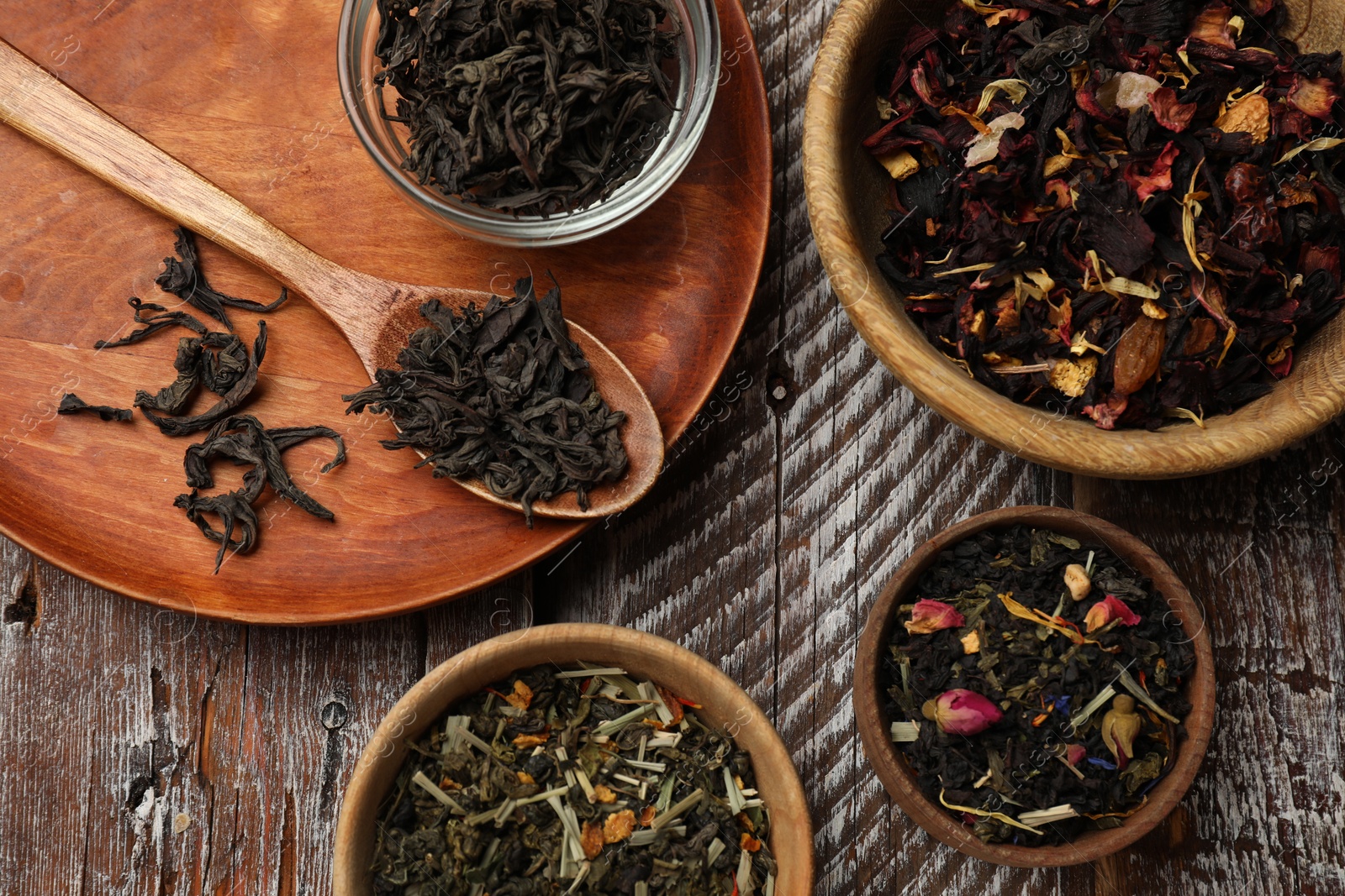 Photo of Different types of tea brew on wooden table, flat lay