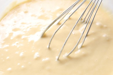 Photo of Whisk and bowl of dough, closeup view