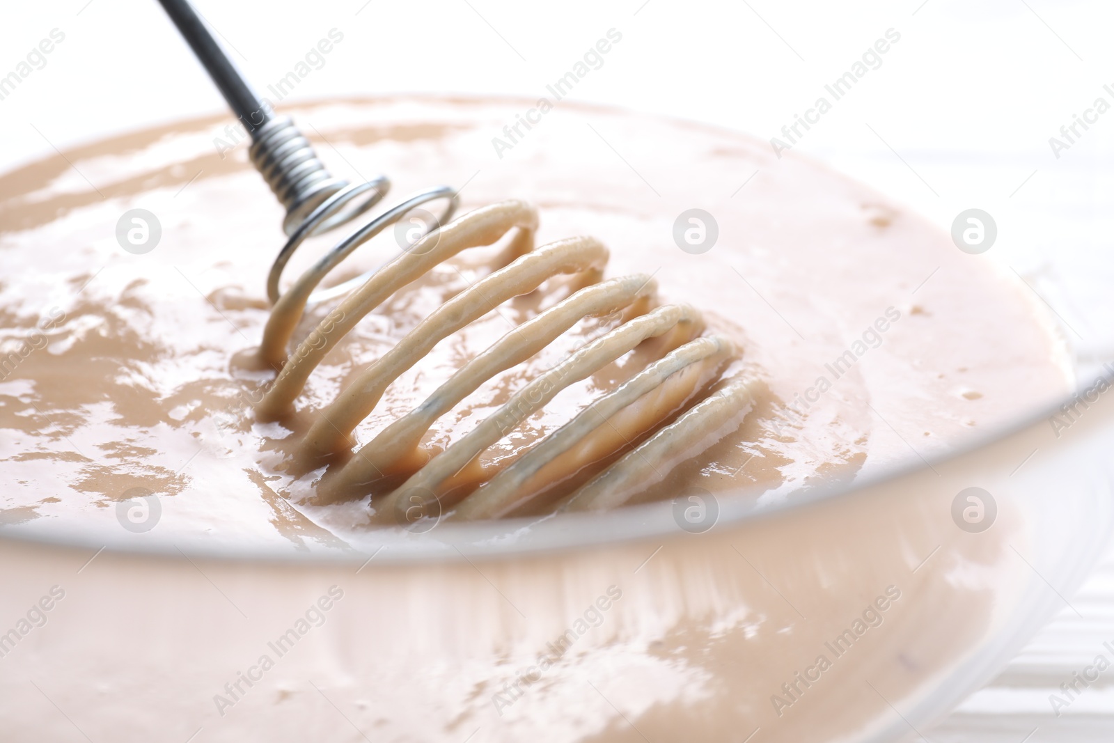 Photo of Whisk and bowl of dough, closeup view