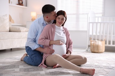 Photo of Pregnant woman and her husband on floor at home