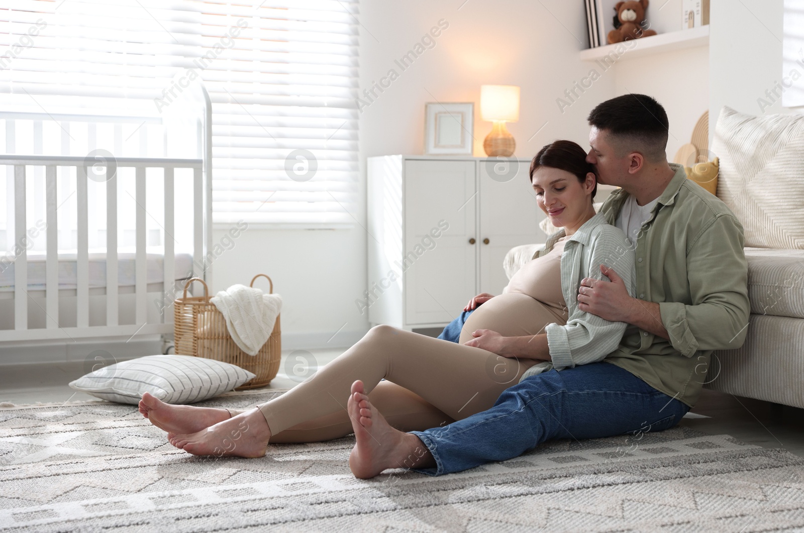 Photo of Pregnant woman and her husband on floor at home