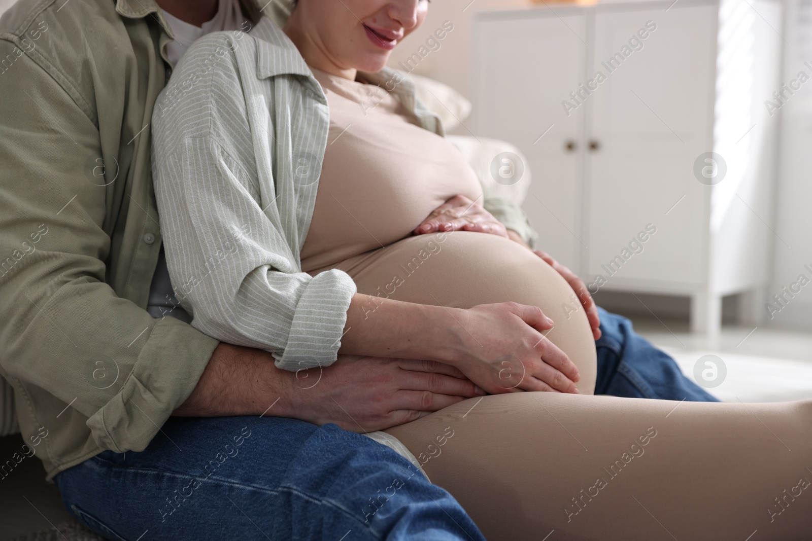 Photo of Pregnant woman and her husband at home, closeup