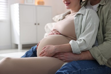 Photo of Pregnant woman and her husband at home, closeup