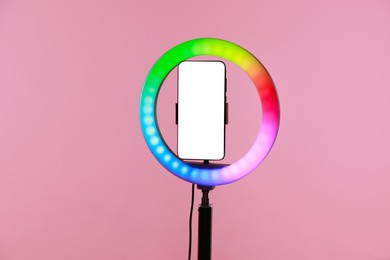 Photo of Ring lamp with smartphone on pink background