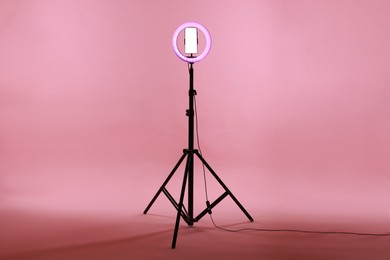 Photo of Ring lamp with smartphone on pink background