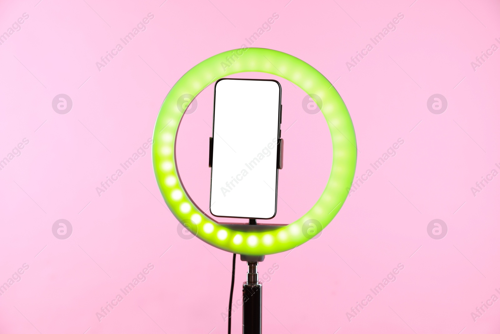 Photo of Ring lamp with smartphone on pink background