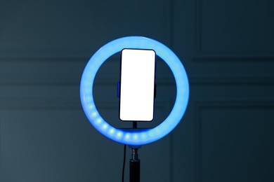 Photo of Ring lamp with smartphone against wall indoors