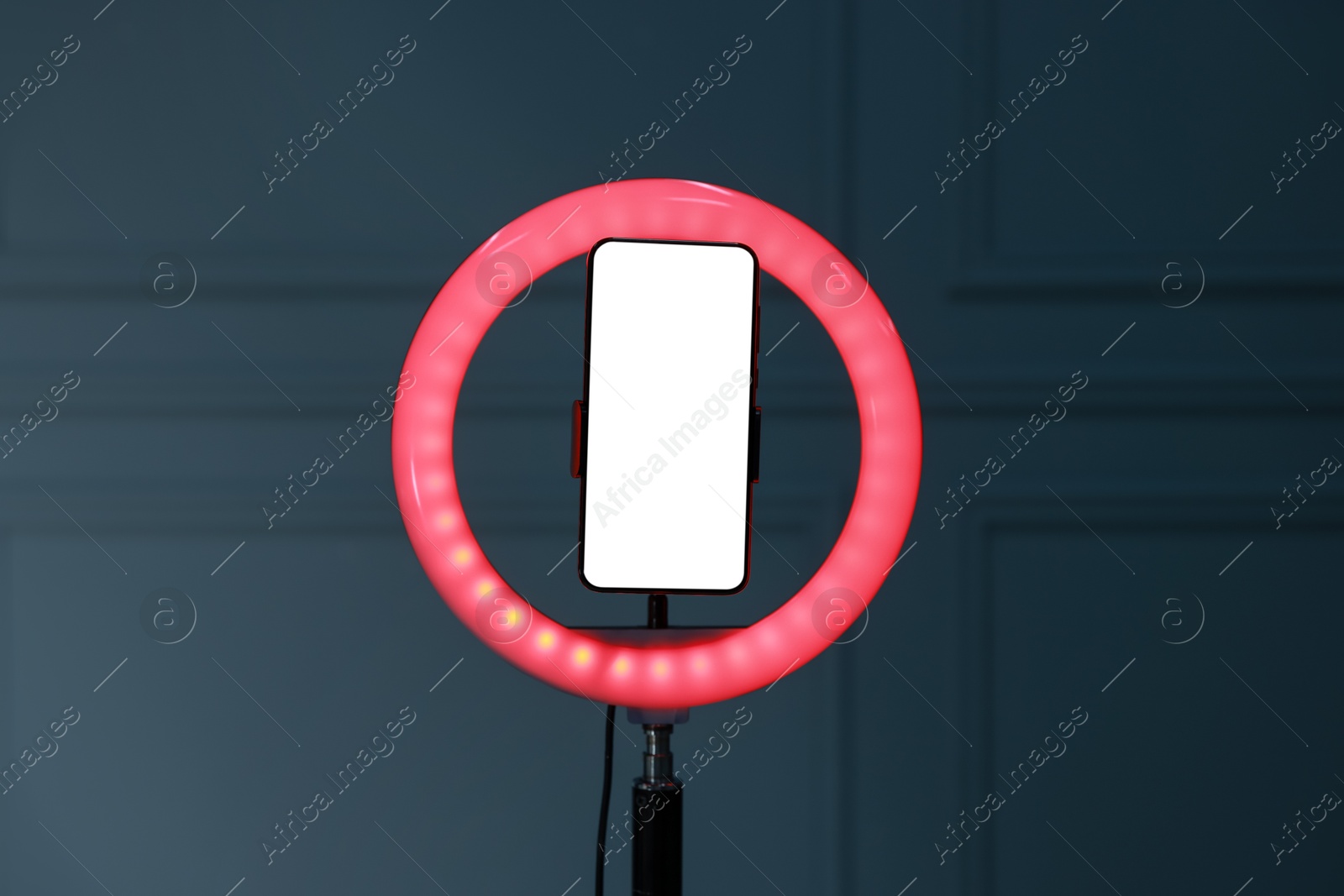 Photo of Ring lamp with smartphone against wall indoors