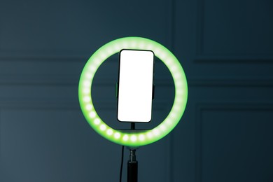 Photo of Ring lamp with smartphone against wall indoors