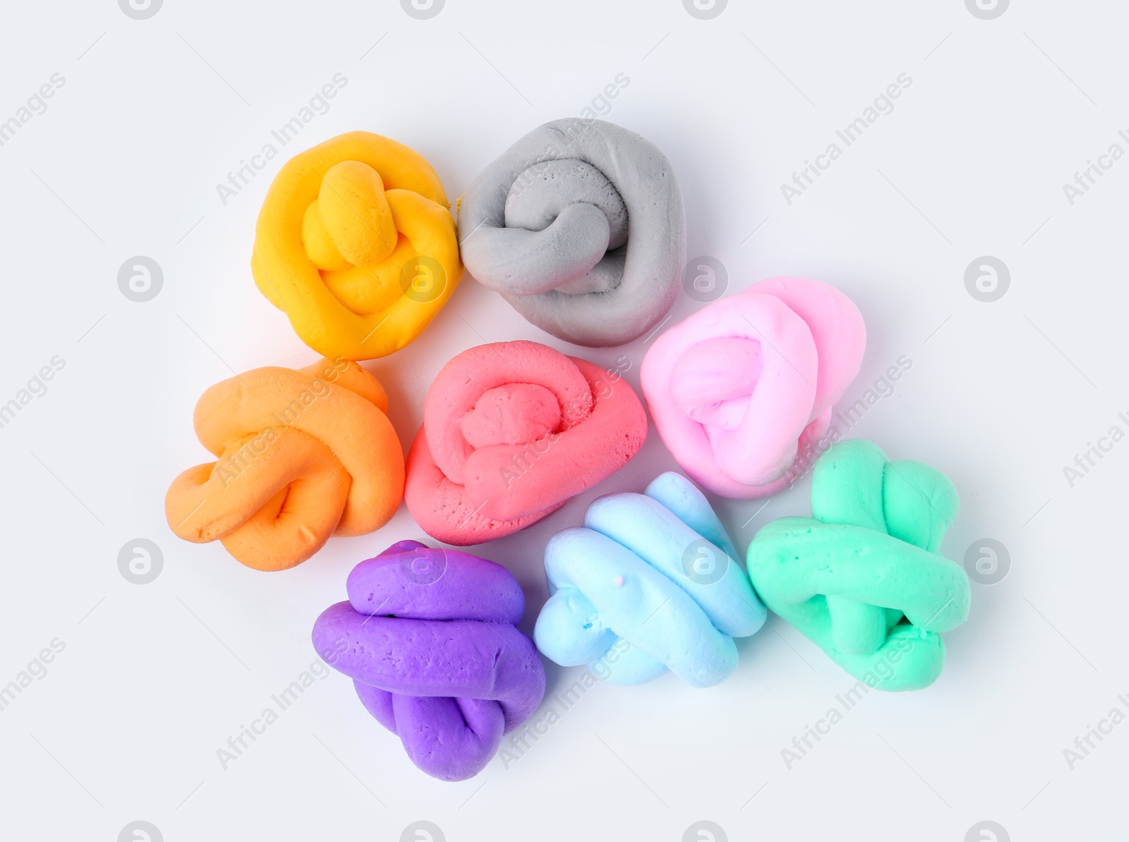 Photo of Different colorful play dough on white background, flat lay