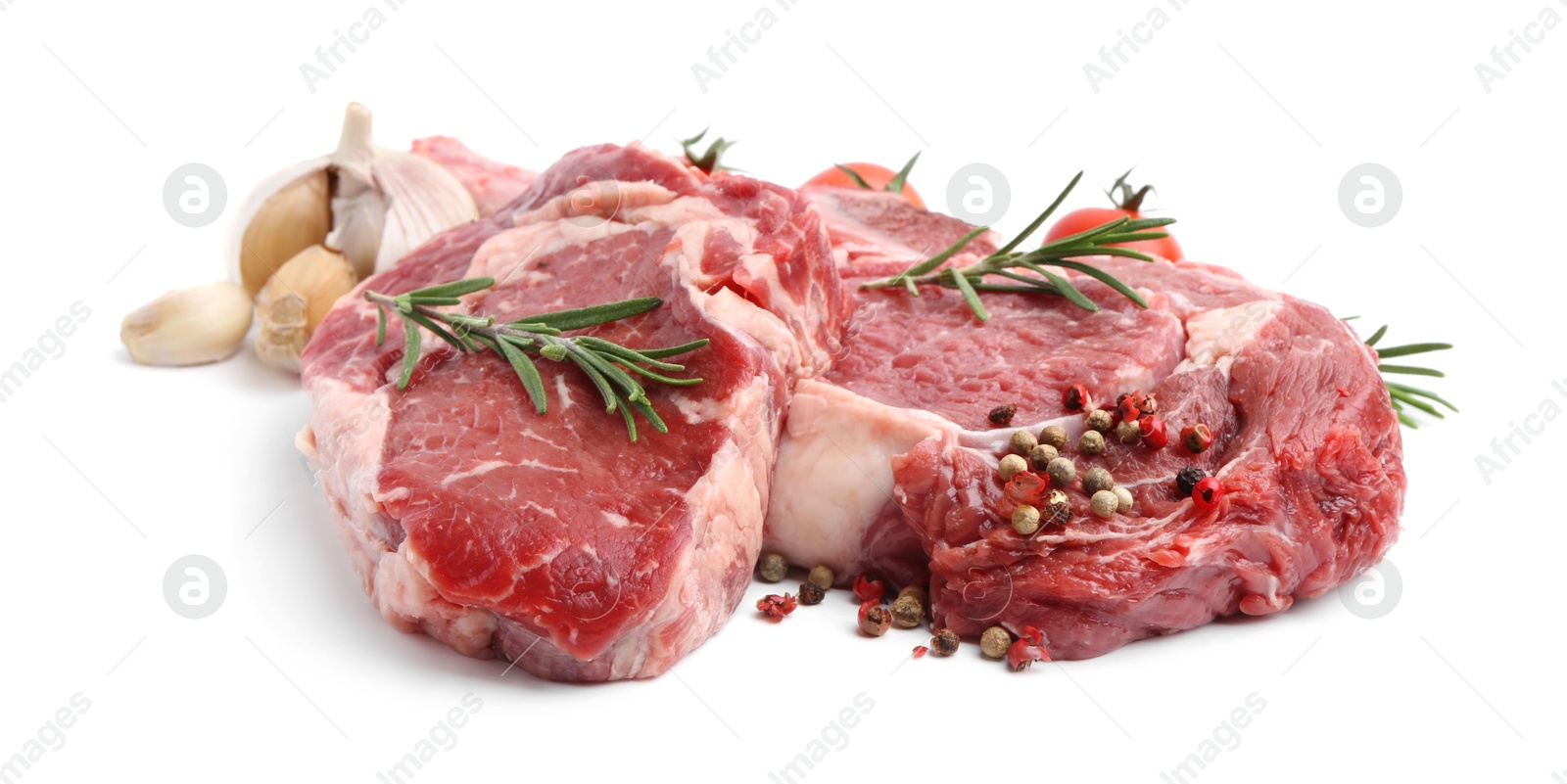 Photo of Pieces of raw beef meat, spices and tomatoes isolated on white