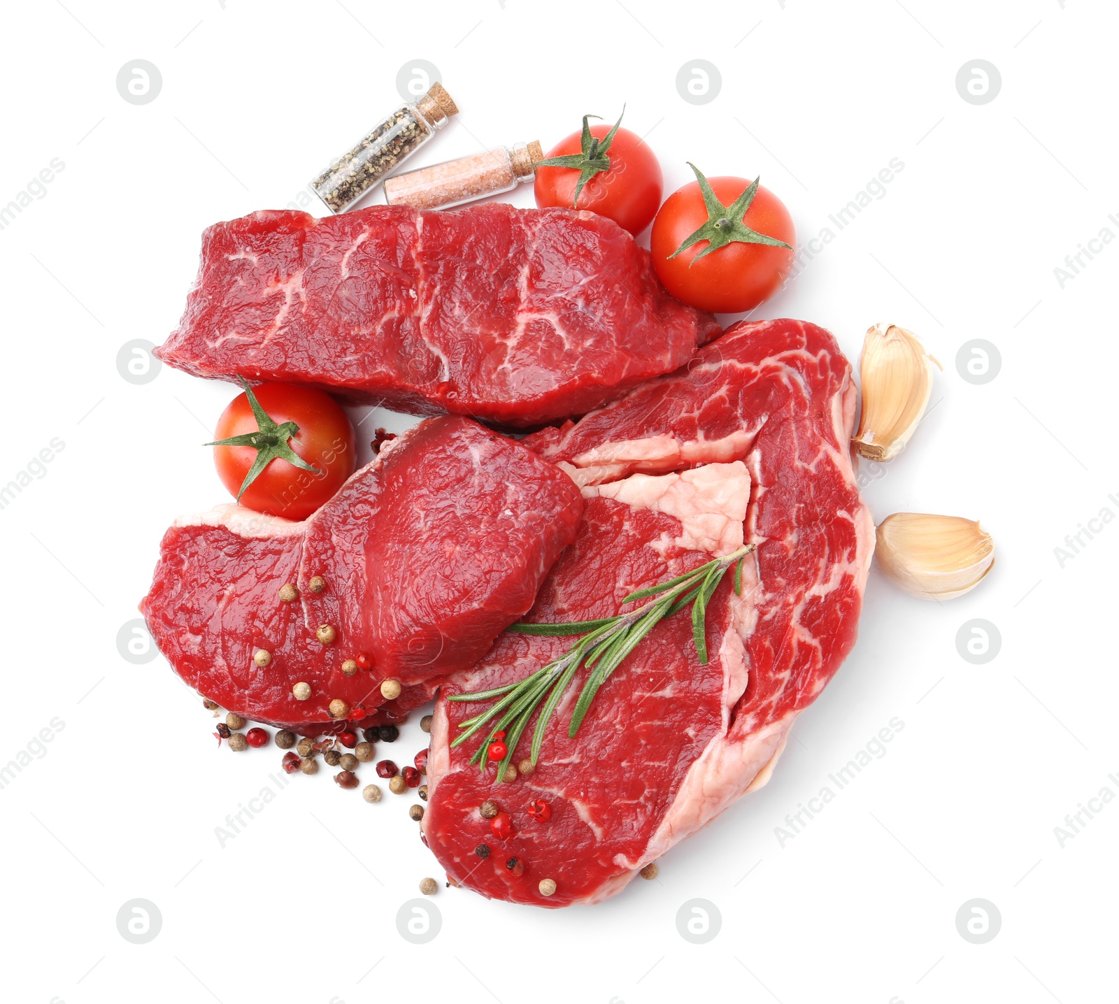 Photo of Pieces of raw beef meat, spices and tomatoes isolated on white, top view