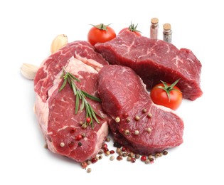 Photo of Pieces of raw beef meat, spices and tomatoes isolated on white