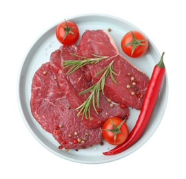 Photo of Pieces of raw beef meat, spices and tomatoes isolated on white