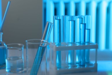 Photo of Laboratory glassware with liquid on table indoors, closeup