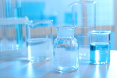 Photo of Laboratory glassware with liquid on table indoors