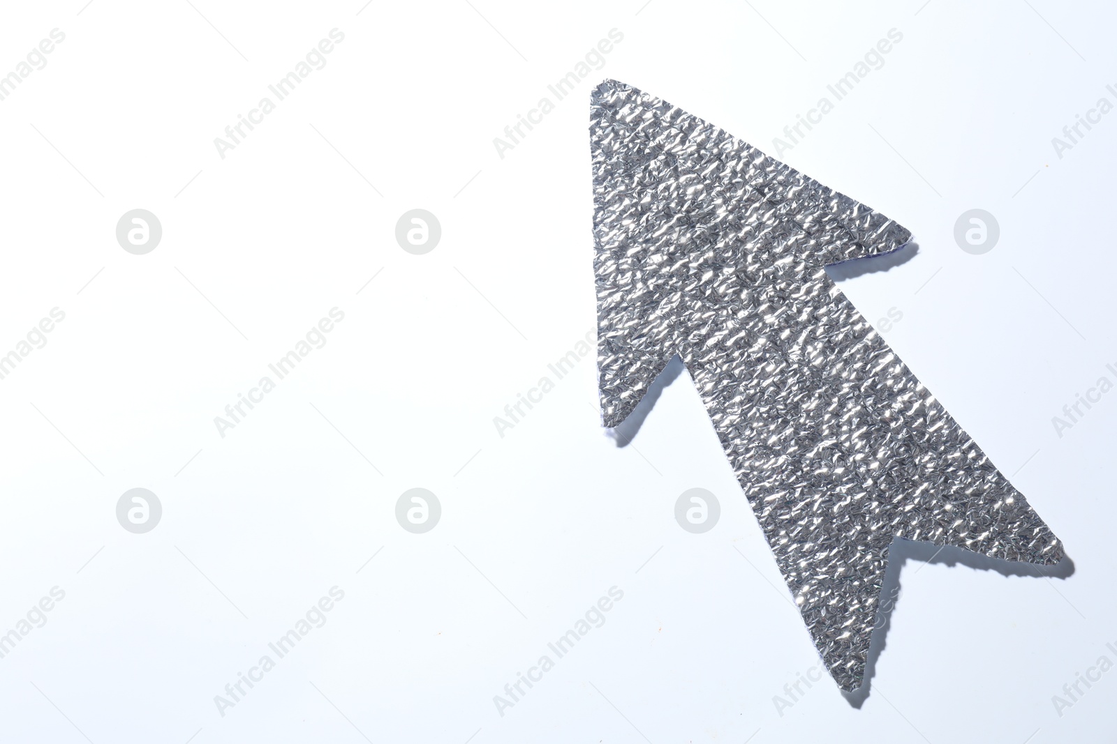 Photo of Silver tinfoil arrow on white background, top view. Space for text